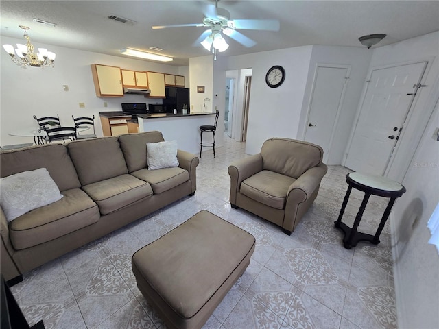 living room featuring ceiling fan with notable chandelier and light tile patterned floors