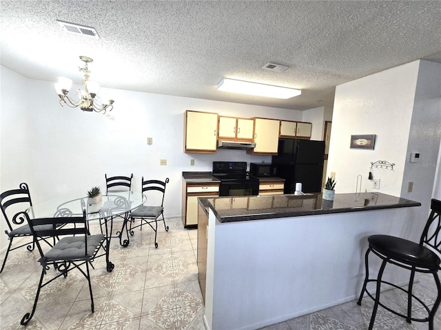 kitchen with an inviting chandelier, kitchen peninsula, a textured ceiling, and black appliances