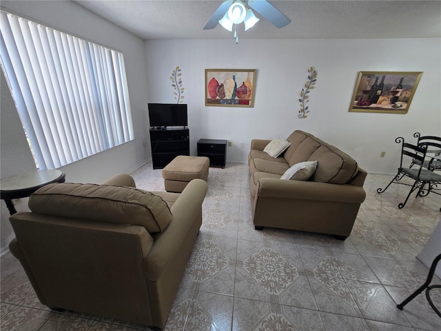 tiled living room featuring ceiling fan and a textured ceiling