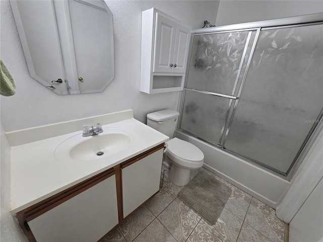 full bathroom featuring vanity, toilet, tile patterned floors, and bath / shower combo with glass door