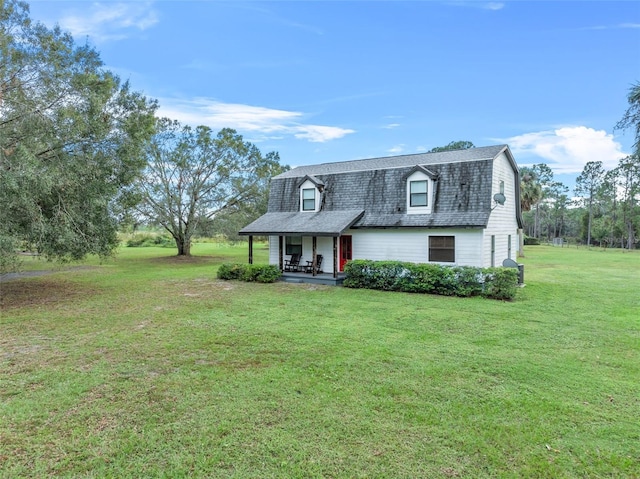 965 Keen Rd, Frostproof, FL 33843 - colonial inspired home featuring a gambrel roof, roof with shingles, a front lawn, and covered porch