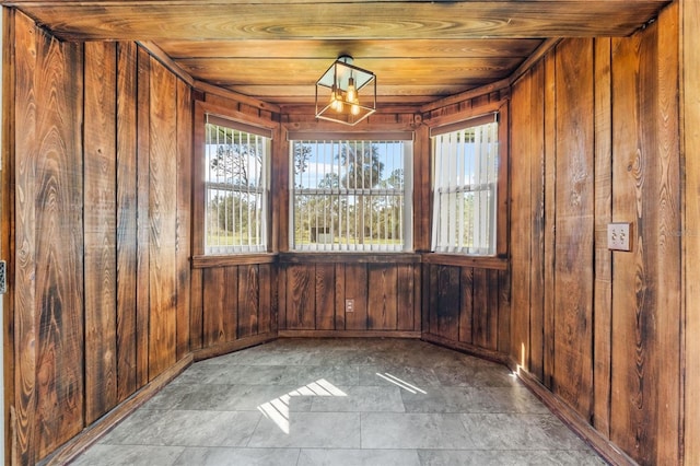 unfurnished room featuring wooden ceiling and wood walls