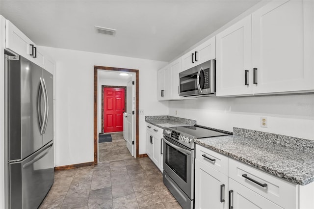 kitchen featuring white cabinets, stainless steel appliances, and light stone counters