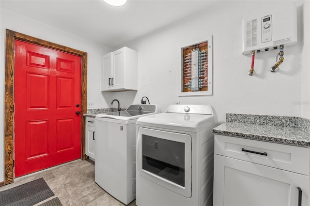 washroom featuring cabinets, washing machine and dryer, and water heater