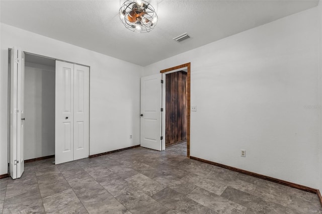 unfurnished bedroom featuring a textured ceiling and a closet