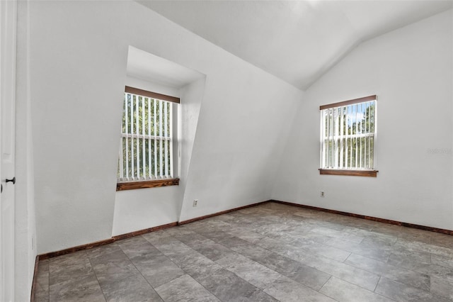 unfurnished room with plenty of natural light and vaulted ceiling