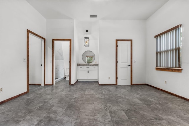 965 Keen Rd, Frostproof, FL 33843 - unfurnished bedroom with multiple windows, baseboards, and connected bathroom