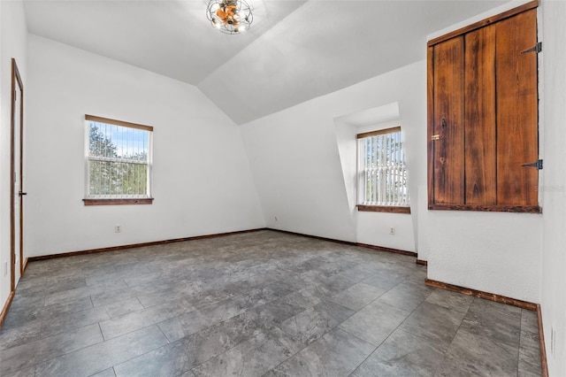 spare room featuring lofted ceiling and a healthy amount of sunlight