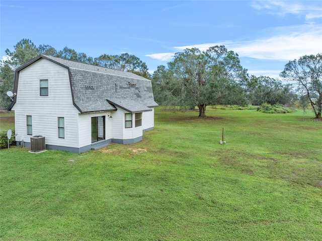 back of house featuring a yard and central AC unit