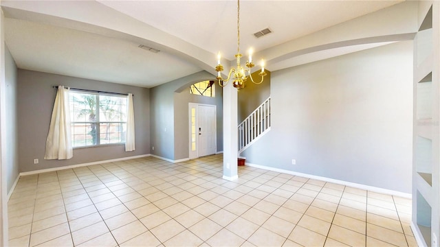 tiled empty room featuring a notable chandelier