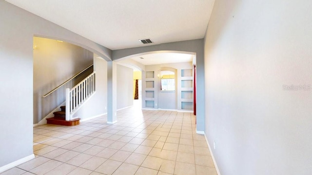 interior space featuring built in shelves and light tile patterned flooring