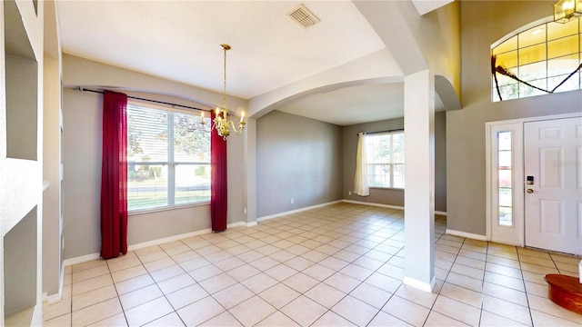 tiled foyer entrance with a chandelier