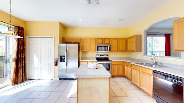 kitchen with stainless steel appliances, a center island, hanging light fixtures, sink, and light tile patterned floors