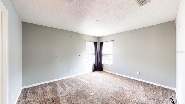 carpeted empty room featuring a textured ceiling