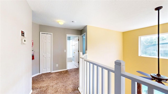 hallway featuring a textured ceiling and carpet