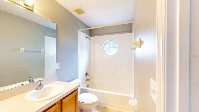 full bathroom featuring vanity, tiled shower / bath, and toilet