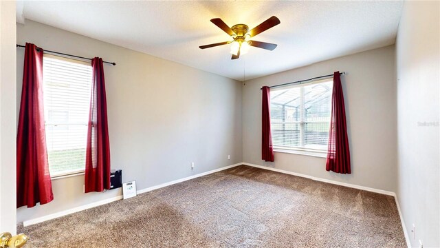 unfurnished room with a textured ceiling, carpet flooring, and ceiling fan