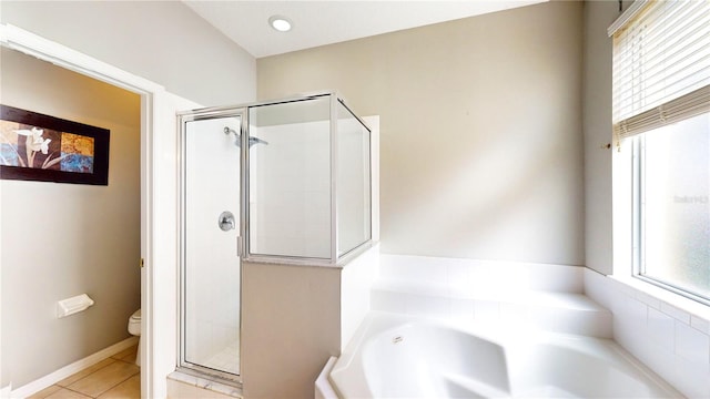 bathroom featuring plus walk in shower, tile patterned floors, and toilet