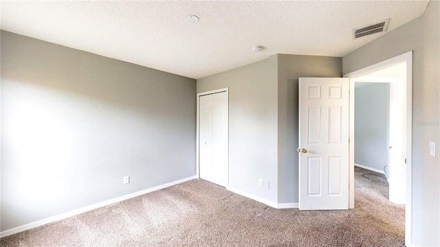 unfurnished bedroom featuring a closet, a textured ceiling, and carpet flooring