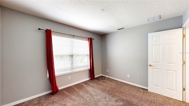 empty room with carpet and a textured ceiling