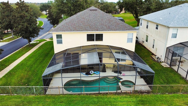 back of property featuring a fenced in pool, a patio, a yard, and glass enclosure