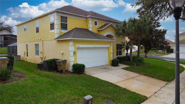 view of front of home featuring cooling unit, a garage, and a front lawn