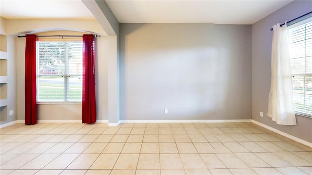 tiled empty room featuring a healthy amount of sunlight