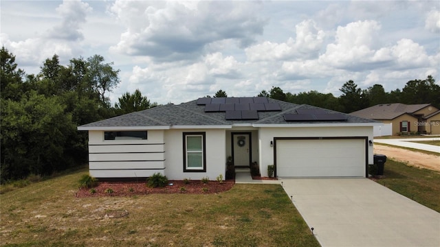 view of front facade with solar panels, a front lawn, and a garage