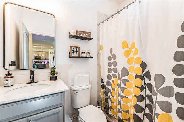 bathroom featuring toilet, vanity, and walk in shower