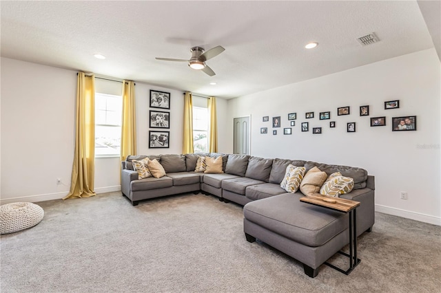 carpeted living room featuring ceiling fan and a textured ceiling