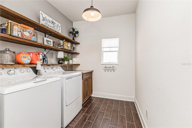 laundry area with dark hardwood / wood-style floors, separate washer and dryer, and cabinets