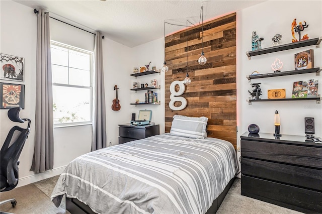 carpeted bedroom with a textured ceiling and wood walls