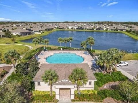 view of pool with a patio area and a water view