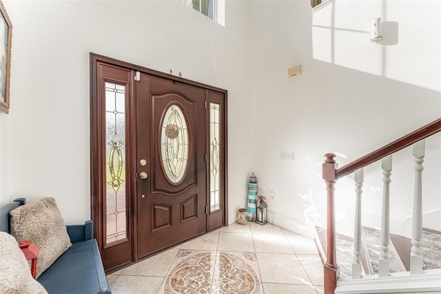 tiled foyer entrance featuring a towering ceiling