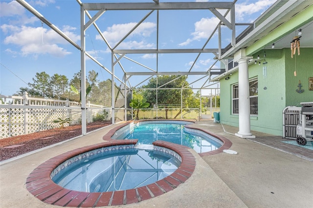 view of pool featuring an in ground hot tub, a patio, and glass enclosure