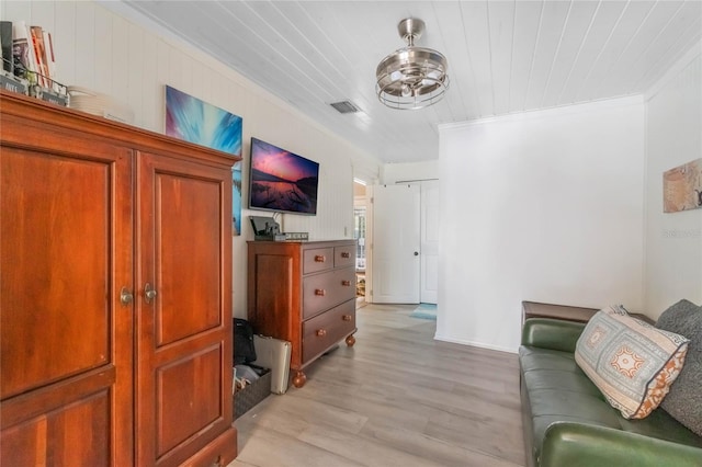 living room with ornamental molding and light wood-type flooring