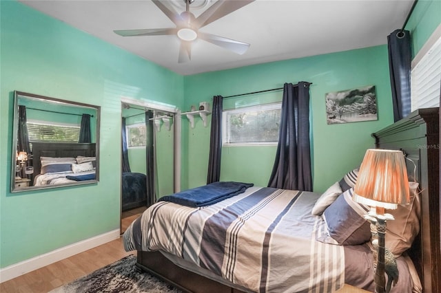 bedroom featuring multiple windows, wood-type flooring, and ceiling fan