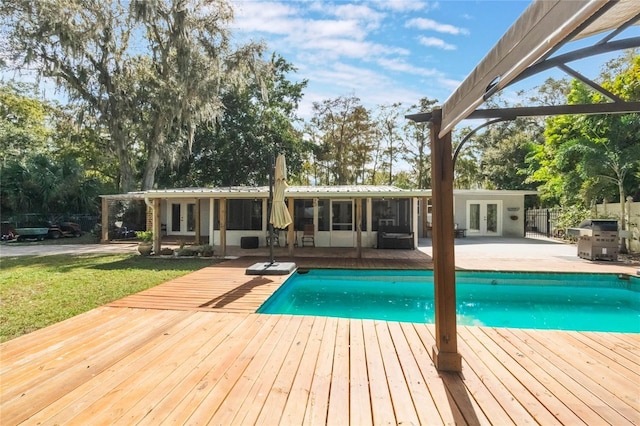 view of pool with french doors, a patio, and a sunroom