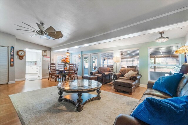 living room featuring ceiling fan, light wood-type flooring, vaulted ceiling, and french doors