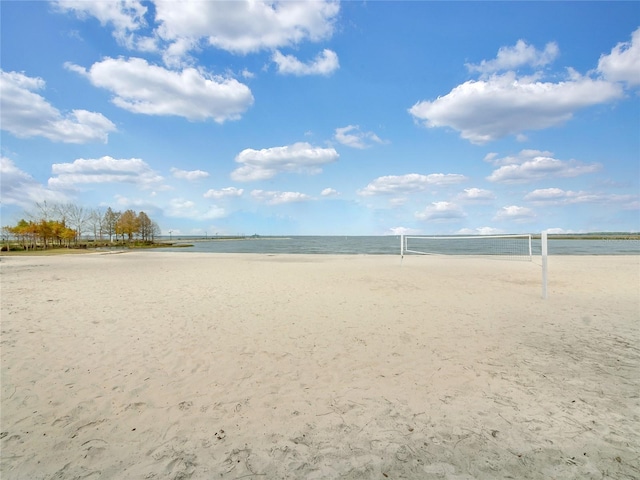 view of home's community featuring a water view, volleyball court, and a beach view