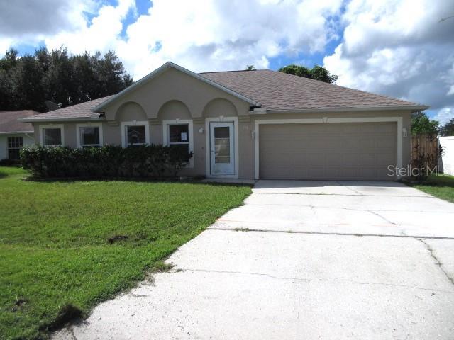 single story home featuring a front yard and a garage