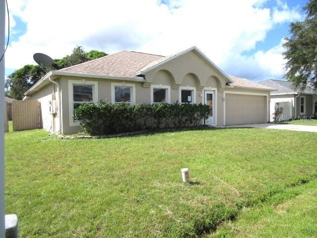 ranch-style house featuring a front yard and a garage