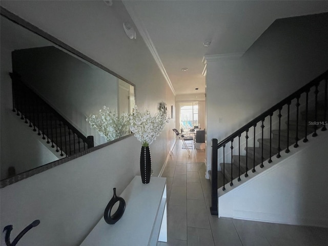 stairway with tile patterned floors and crown molding