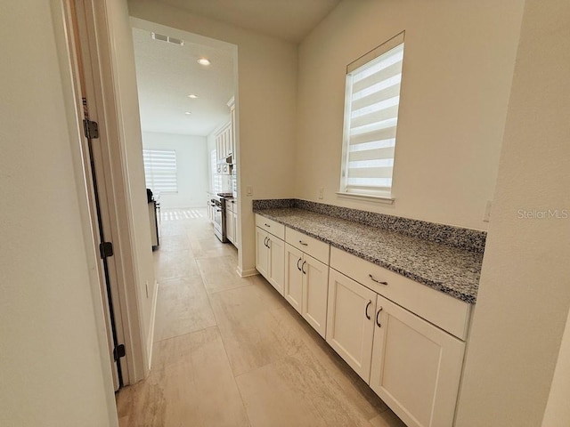 corridor with baseboards, visible vents, and recessed lighting