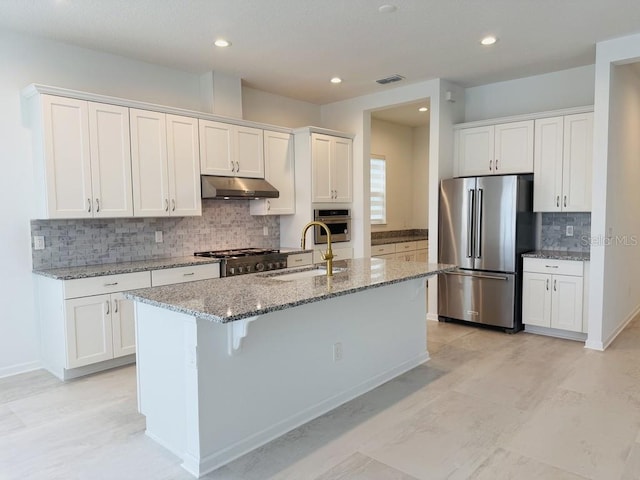 kitchen featuring under cabinet range hood, white cabinetry, a kitchen island with sink, and appliances with stainless steel finishes