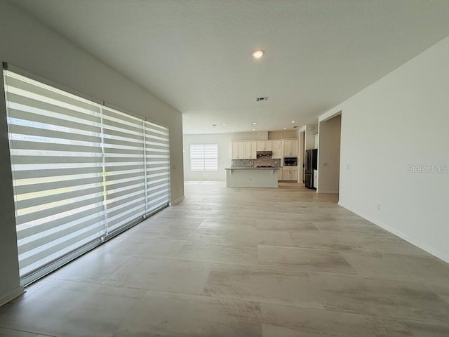 interior space featuring baseboards, visible vents, and recessed lighting