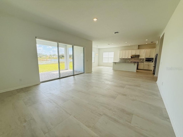 unfurnished living room featuring visible vents, baseboards, and recessed lighting