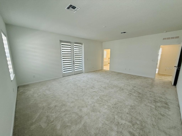 unfurnished bedroom with baseboards, visible vents, and light colored carpet