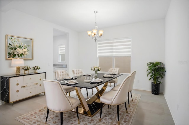 dining room featuring baseboards and a notable chandelier