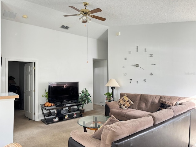 living room with ceiling fan, a textured ceiling, light carpet, and lofted ceiling